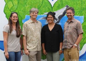 Research team taking a picture together in front of a whale mural.