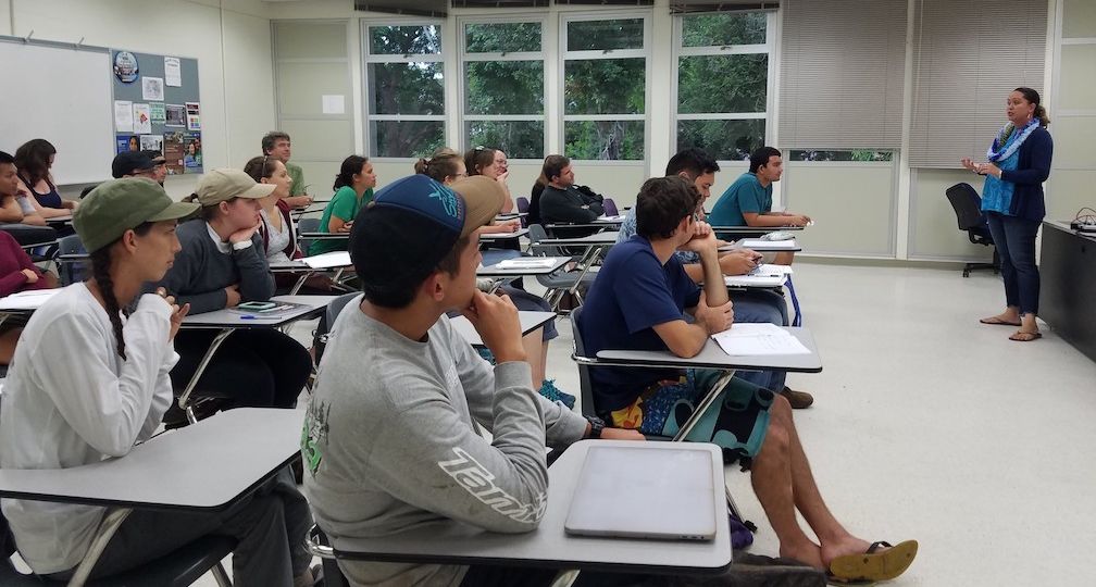 MCC partner Ulu Ching presenting in front of classroom of graduate students.