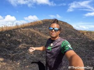 Farron Taijeron gestures towards piece of scorched land