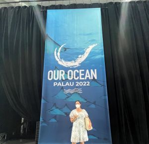 PICASC Staff Heather Kerkering photographed in front of Our Ocean Palau 2022 sign.