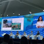 Our Ocean main panel stage with Climate Envoy for the Marshall Islands Tina Stege giving a presentation on the main screens. The panel has an ocean and islets design.