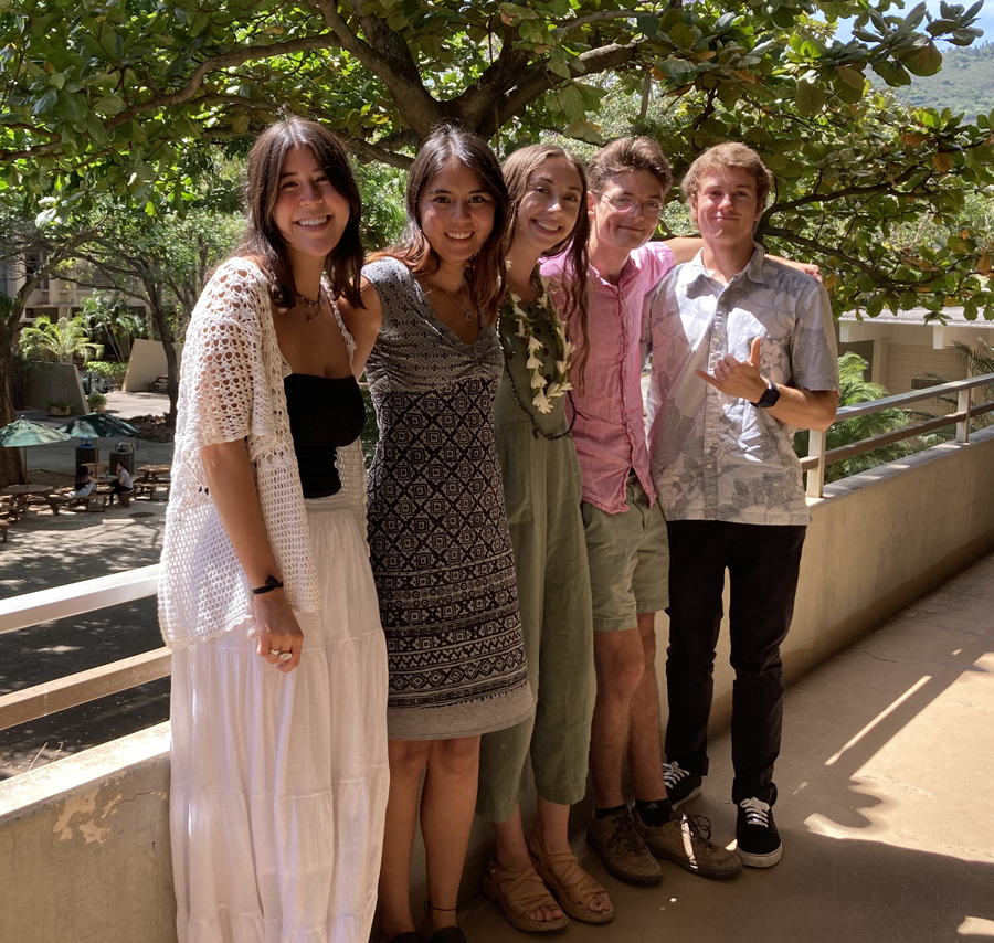 Five undergraduate students pose along a walkway