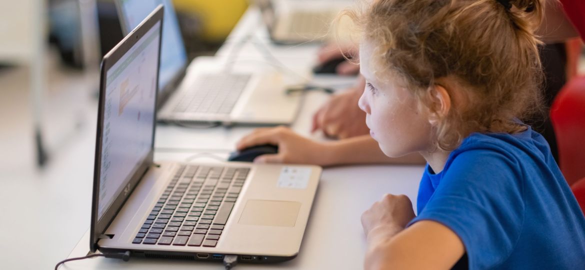 School children using computers in classroom at school.