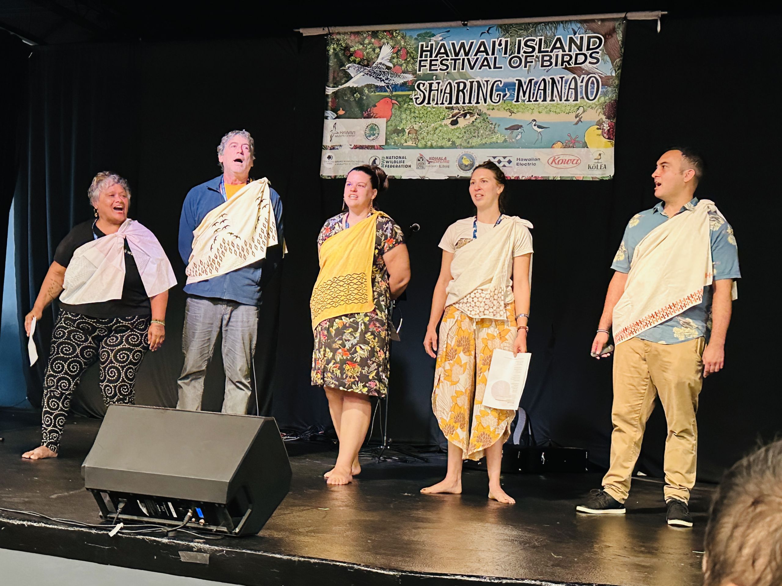 Hart stands with other members of 'Ahuimanu on stage and performs oli