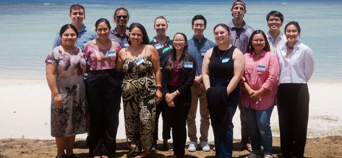 Group photo of Graduate Scholars standing outside on the beach.
